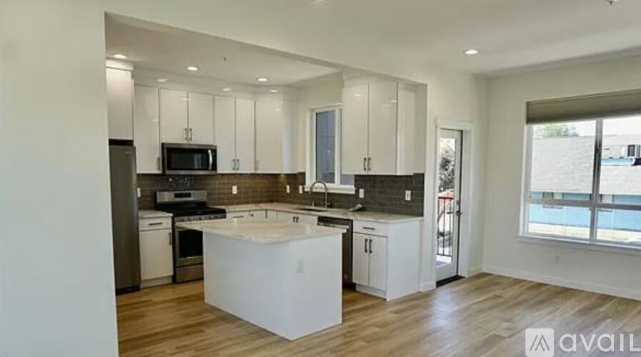 A modern kitchen with white cabinets and a central island.