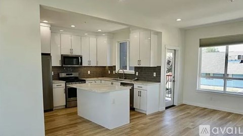 A modern kitchen with white cabinets and a central island.