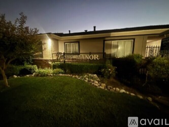 A house with the word "MANUOR" on the front lawn.