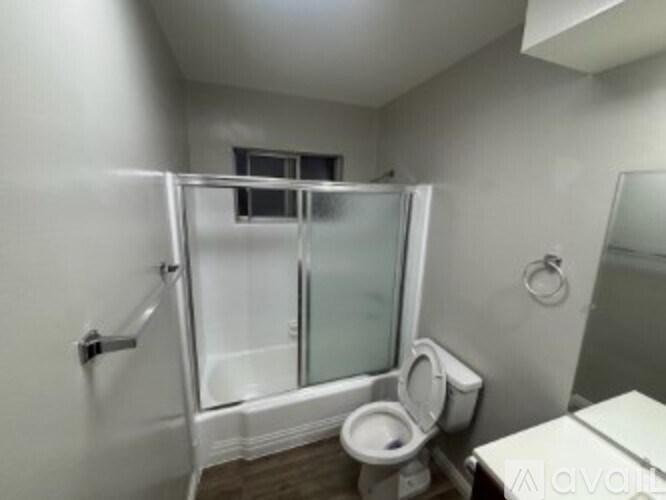 A bathroom with a toilet, sink, and shower.