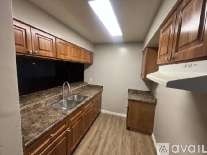 A kitchen with brown cabinets and a granite countertop.