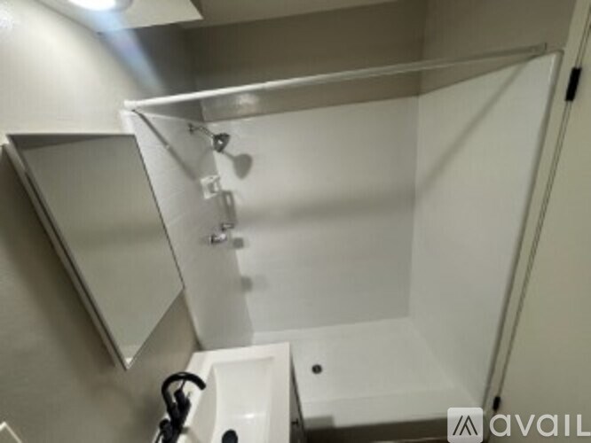 A bathroom with a sink and a shower stall.