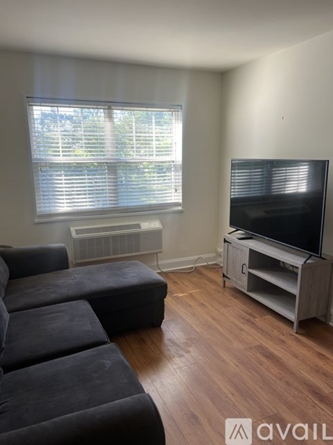 A living room with a black sofa and a television.