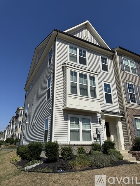 A two-story residential building with a front yard.
