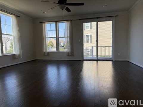 A spacious room with a ceiling fan and sliding glass doors.