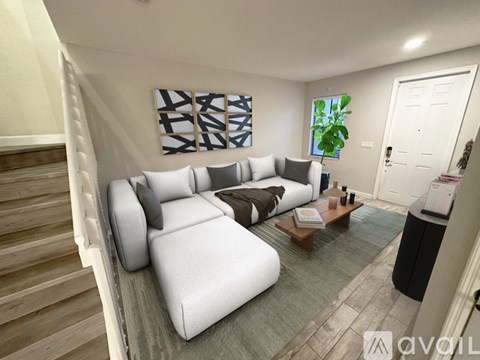 A living room with a white couch and a painting on the wall.