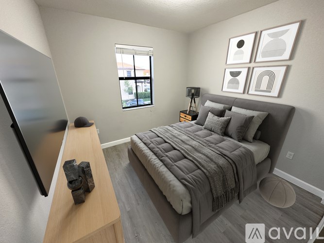 A bedroom with a bed, a television, and a window.