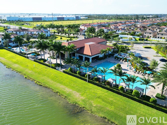 A bird's eye view of a resort with a pool and palm trees.