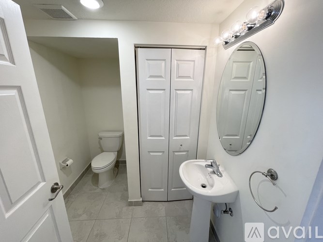 A bathroom with a toilet, sink, and mirror.