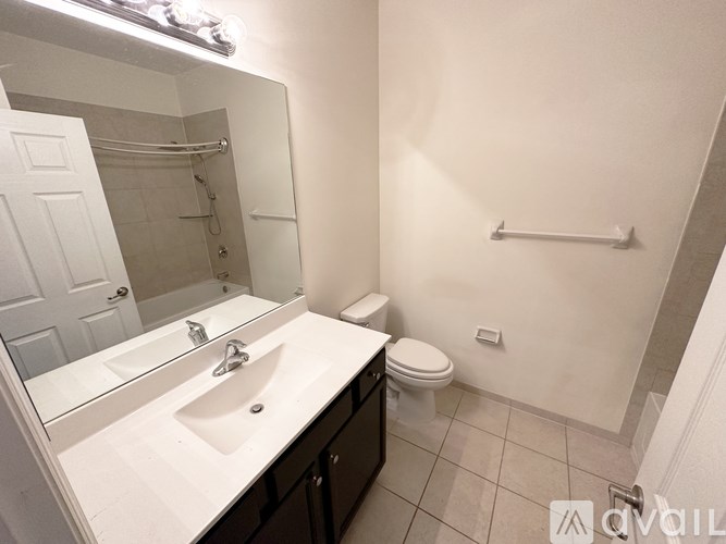 A bathroom with a sink, toilet, and a mirror.