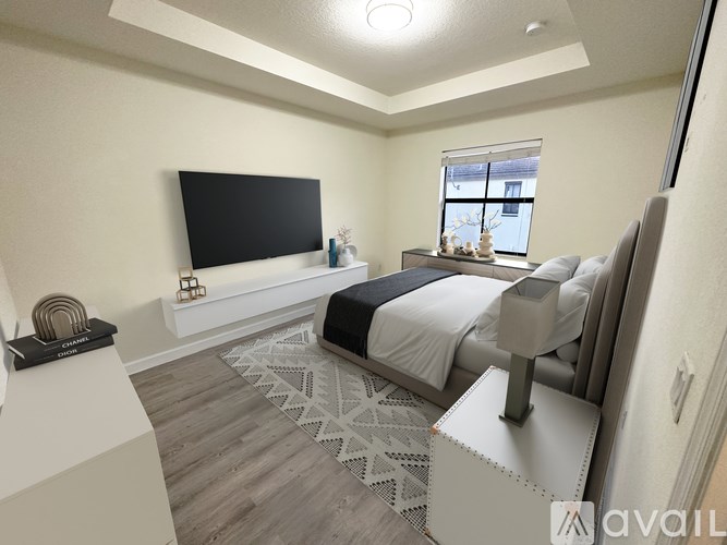 A bedroom with a large bed and a flat screen TV mounted on the wall.