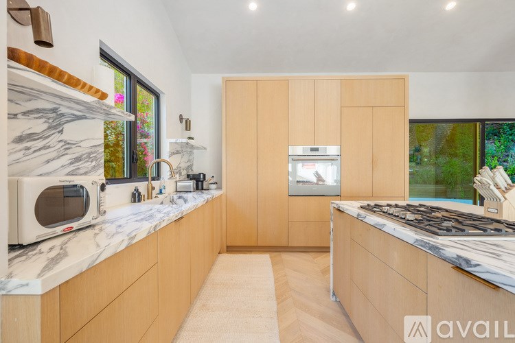 A kitchen with wooden cabinets and marble countertops.