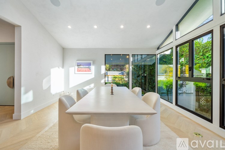 A modern dining room with a large table and chairs.