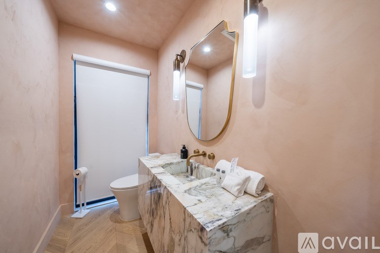 A bathroom with a marble countertop and a large mirror.