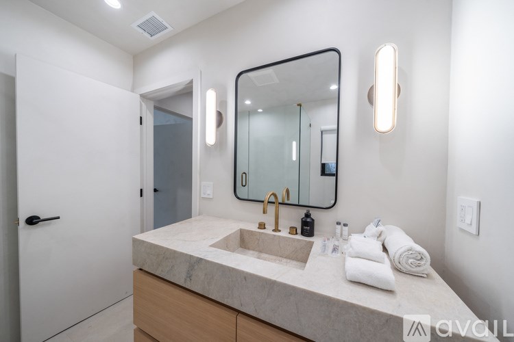 A bathroom with a marble countertop and a large mirror.