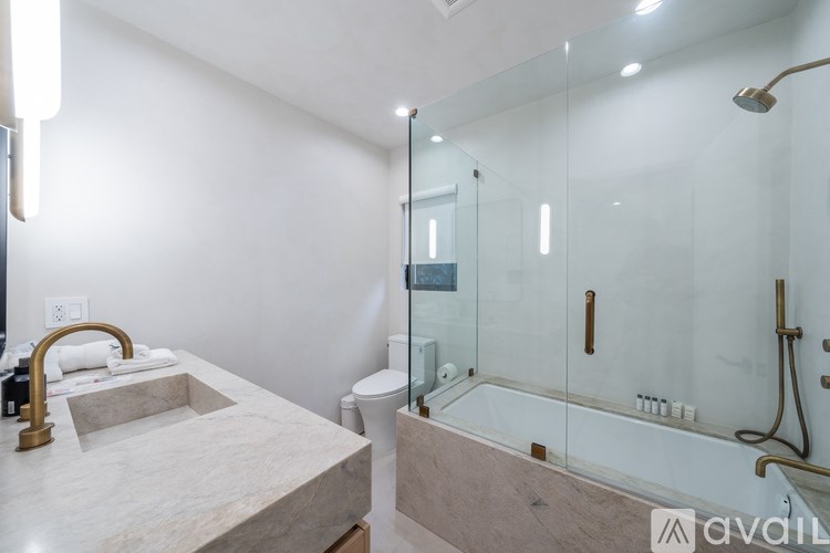 A modern bathroom with a marble countertop and a walk-in shower.
