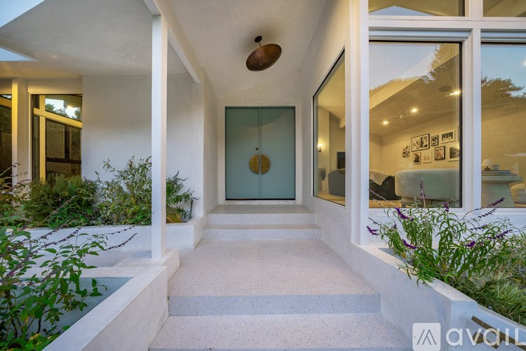 A white house with a blue door and a glass window.