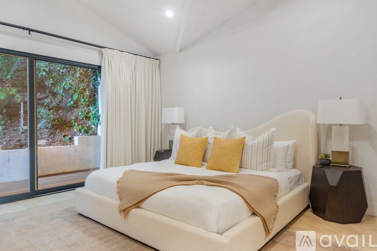 A bedroom with a large bed and a sliding glass door.