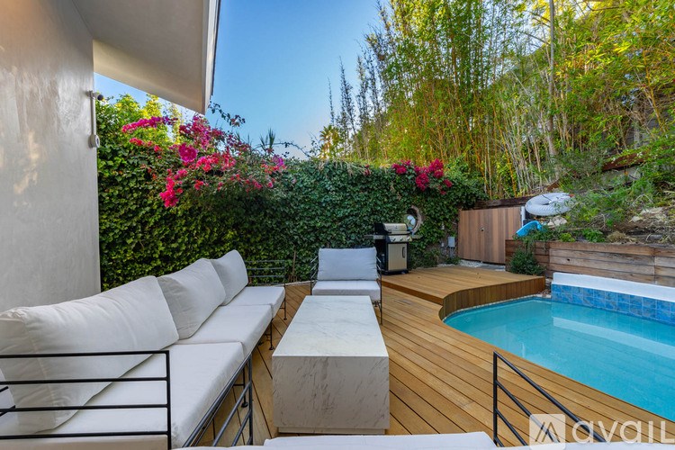 A poolside lounge area with a white couch and a pool.