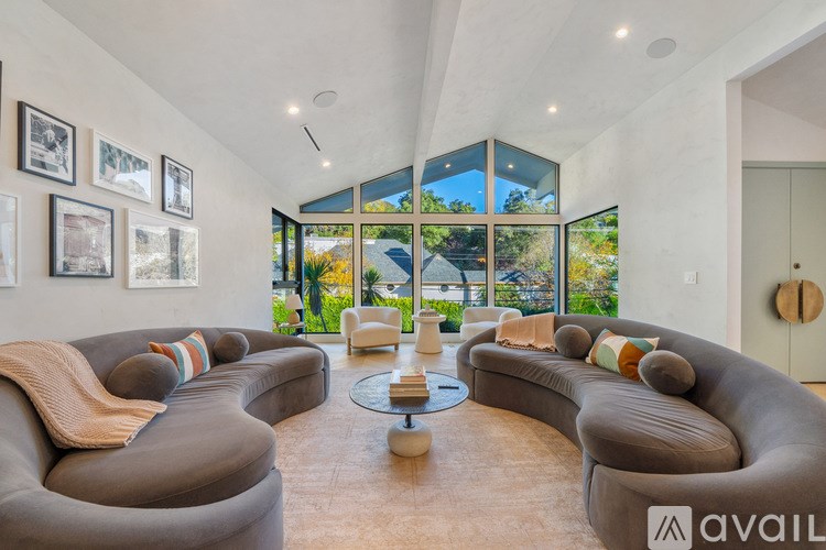 A living room with a large grey sofa and a glass table.