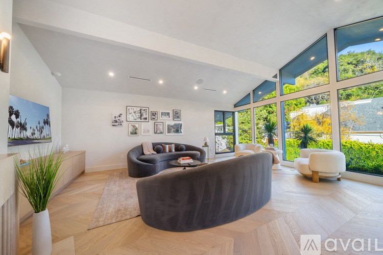 A modern living room with a large grey sofa and a wooden floor.