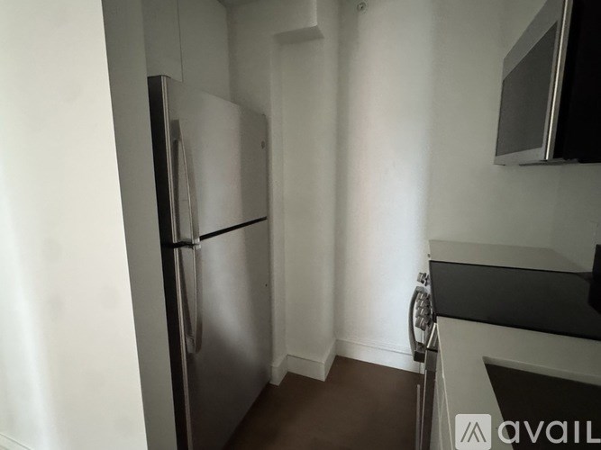 A kitchen with a refrigerator and a microwave.