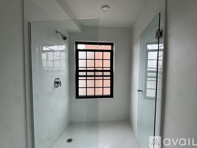 A bathroom with a window and a shower.