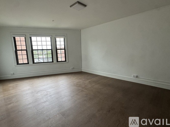 A room with a window and wooden flooring.