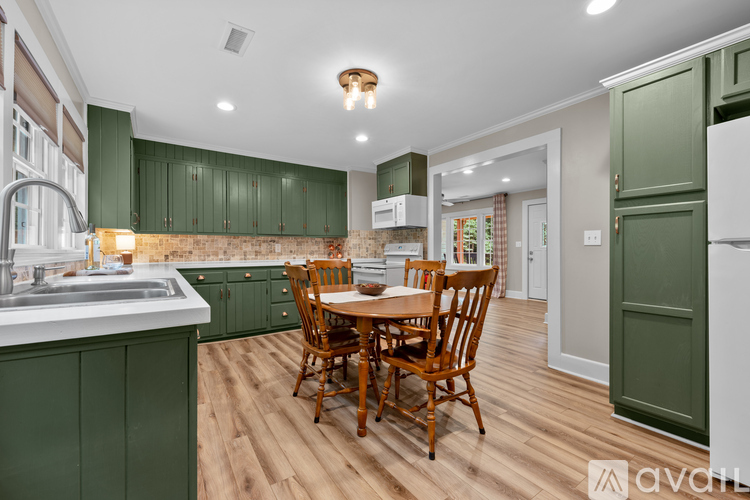 A kitchen with green cabinets and a wooden table.