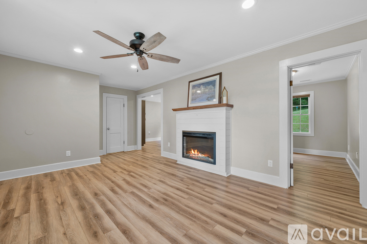 A living room with a fireplace and a ceiling fan.