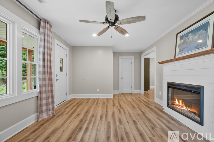A spacious room with a fireplace and a ceiling fan.