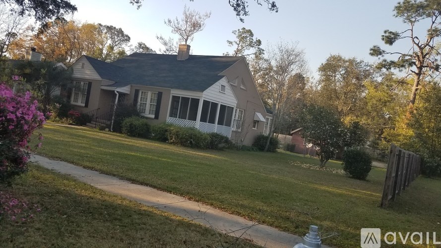 A house with a lawn and trees in the background.