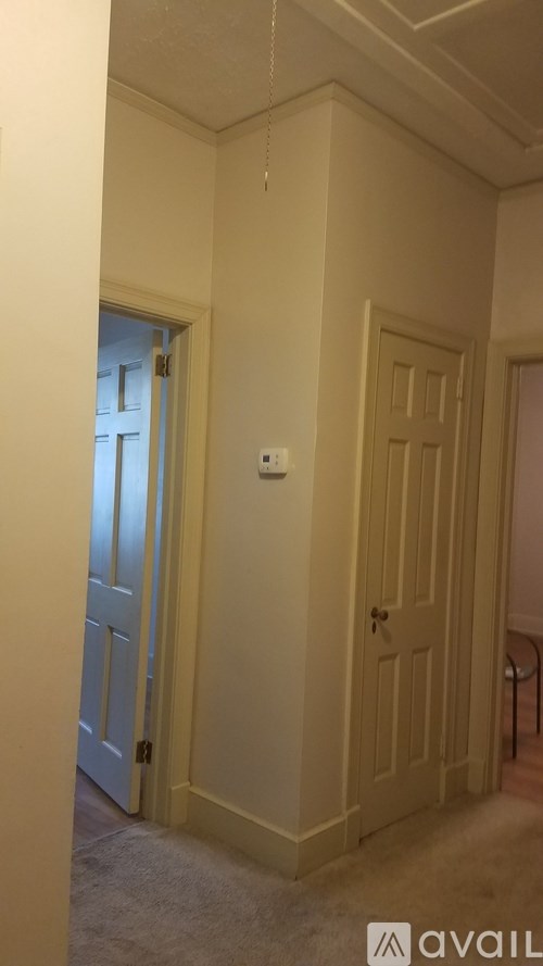 A hallway with a door on the right and a window on the left.