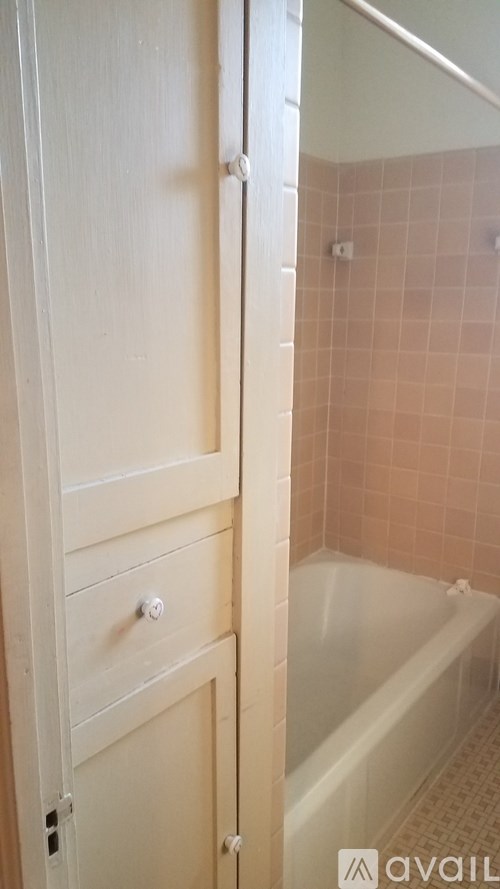 A white bathroom with a tub and a door.