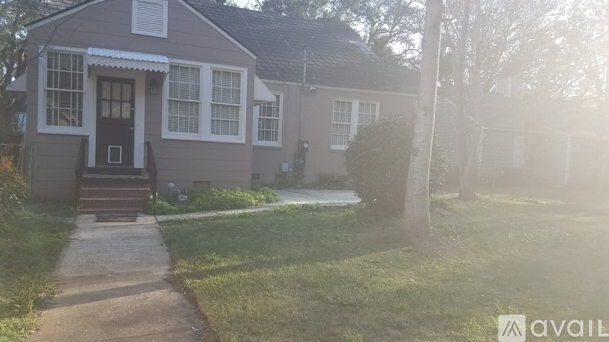A house with a front yard and a pathway leading to the front door.
