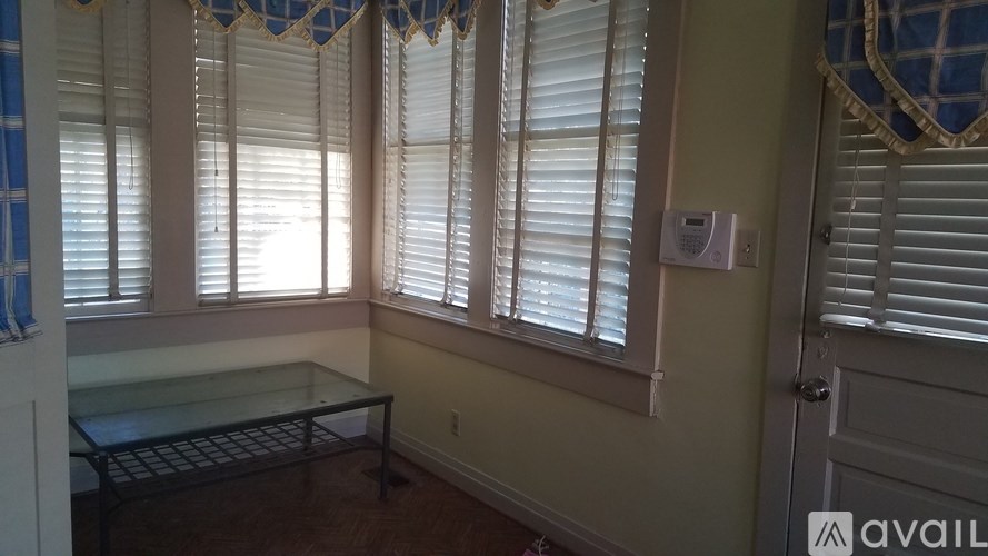 A room with a bench and a window with blinds.