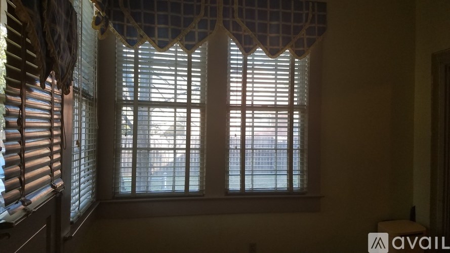 A window with white blinds and a checkered valance.