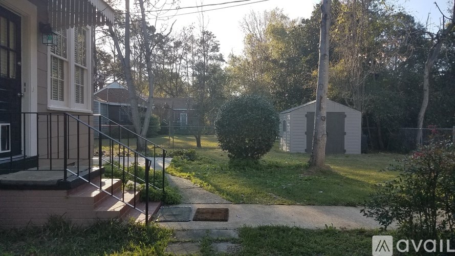 A house with a porch and a tree in front of it.