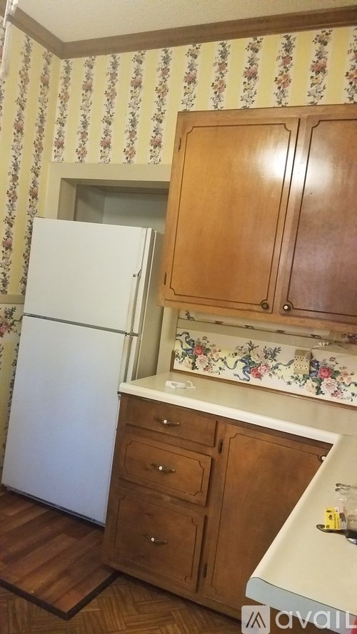 A kitchen with wooden cabinets and a white fridge.