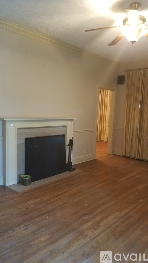 A room with a fireplace and wooden floors.