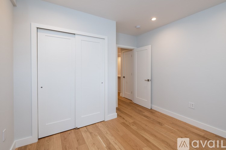 A room with two white doors and a wooden floor.