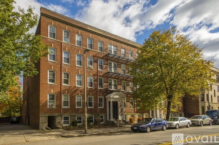A red brick building with a tree in front of it.