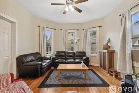 A living room with a black leather couch and a wooden coffee table.