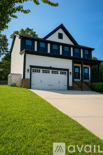 A two-story house with a garage and a driveway.