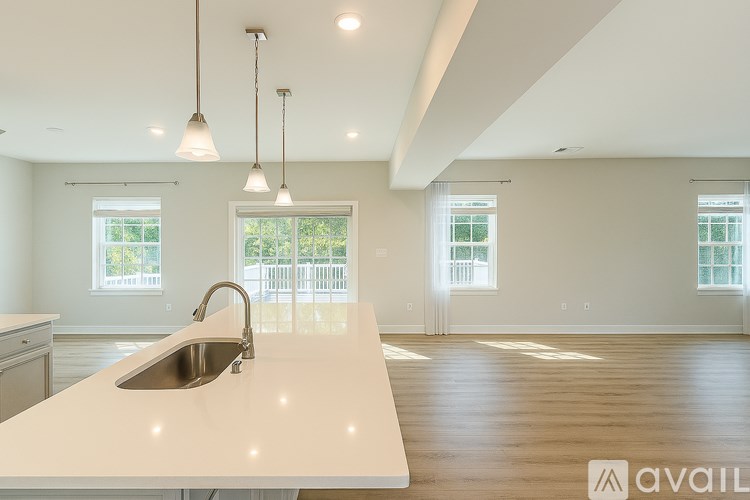 A kitchen with a white countertop and a stainless steel sink.