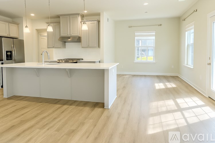 A kitchen with wooden floors and white cabinetry.