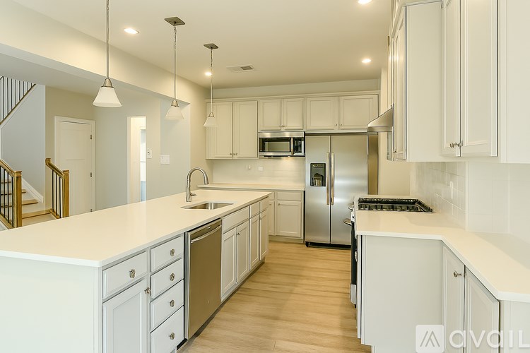 A modern kitchen with white cabinets and stainless steel appliances.