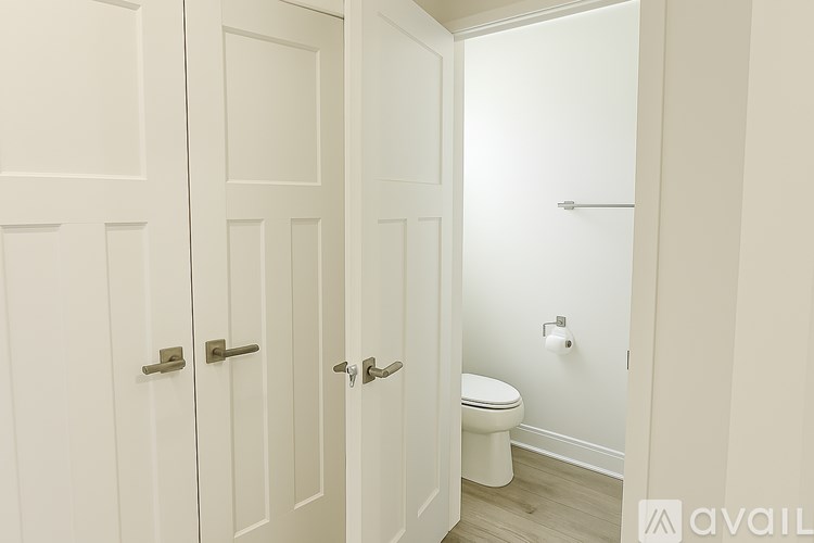 A white bathroom with a toilet and a door.