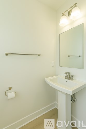 A white sink in a bathroom with a mirror and a towel bar.