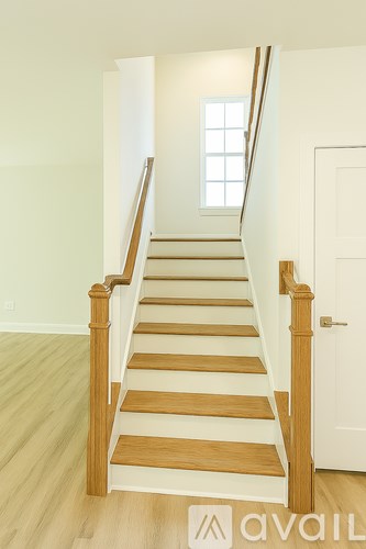 A wooden staircase with a white door and window.